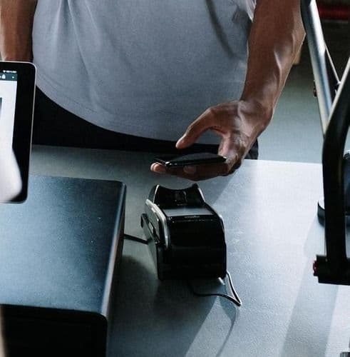 Client passant commande sur une borne d'encaissement tactile dans un restaurant rapide